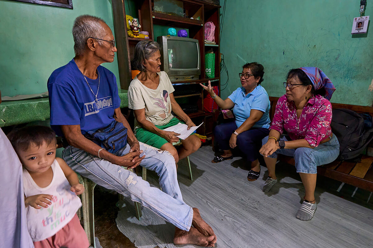 United Methodist deaconesses Norma Dollaga (right) and Rubylin Litao talk with Bienvenido and Estrella Nonay in Caloocan, Philippines. The Nonays’ son Bernardo was assassinated in 2018, one of thousands of extrajudicial killings carried out as part of Philippine President Rodrigo Duterte’s controversial "war on drugs." The deaconesses are founders of Rise Up for Life and for Rights, which unites family and friends of victims and advocates in demanding an end to the violence and punishment for those responsible. Photo by Paul Jeffrey, UM News.