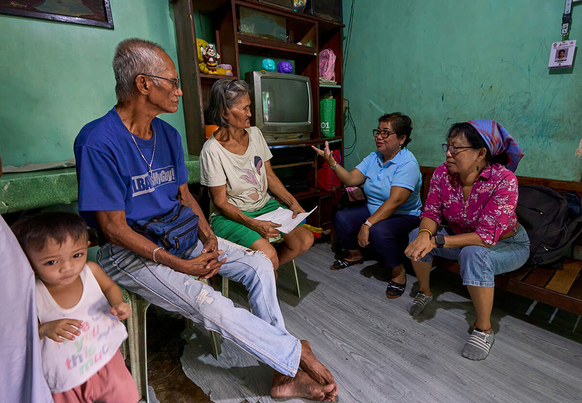 United Methodist deaconesses Norma Dollaga (right) and Rubylin Litao talk with Bienvenido and Estrella Nonay in Caloocan, Philippines. The Nonays’ son Bernardo was assassinated in 2018, one of thousands of extrajudicial killings carried out as part of Philippine President Rodrigo Duterte’s controversial "war on drugs." The deaconesses are founders of Rise Up for Life and for Rights, which unites family and friends of victims and advocates in demanding an end to the violence and punishment for those responsible. Photo by Paul Jeffrey, UM News.