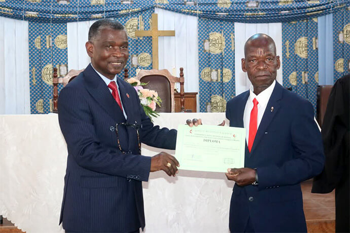 Bispo Gaspar Joaão Domingos faz a entrega do Certificado de Missionário há um dos participantes do 1º curso de missionários na CAOA em Luanda. Foto de Orlando da Cruz, UM News.
