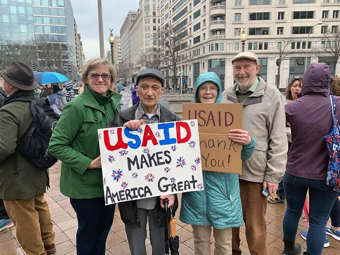 The Rev. Stephanie Vader (left), senior pastor of Capitol Hill United Methodist Church, joins with parishioners in a protest in support of the U.S. Agency for International Development. USAID, which was established by Congress to distribute U.S. foreign aid, is being dismantled by the Trump administration without congressional action. Vader made the sign that says “USAID Makes America Great.” She said a parishioner who worked with the agency is most concerned that the suspension of the agency’s funds and work will cost lives on the continent of Africa. Photo courtesy of the Rev. Stephanie Vader, Capitol Hill United Methodist Church.