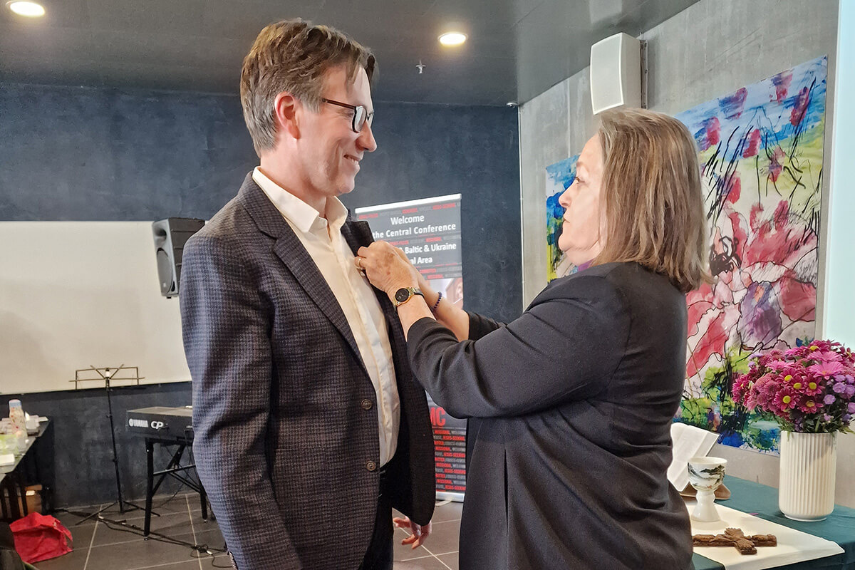 The Rev. Knut Refsdal receives the episcopal pin from Bishop Dottie Escobedo-Frank after being elected a United Methodist bishop on April 4 at the Northern Europe and Eurasia Central Conference in Copenhagen, Denmark. Refsdal, a pastor in Norway, was elected on the 26th ballot. Photo by Karl Anders Ellingsen, UM News. 