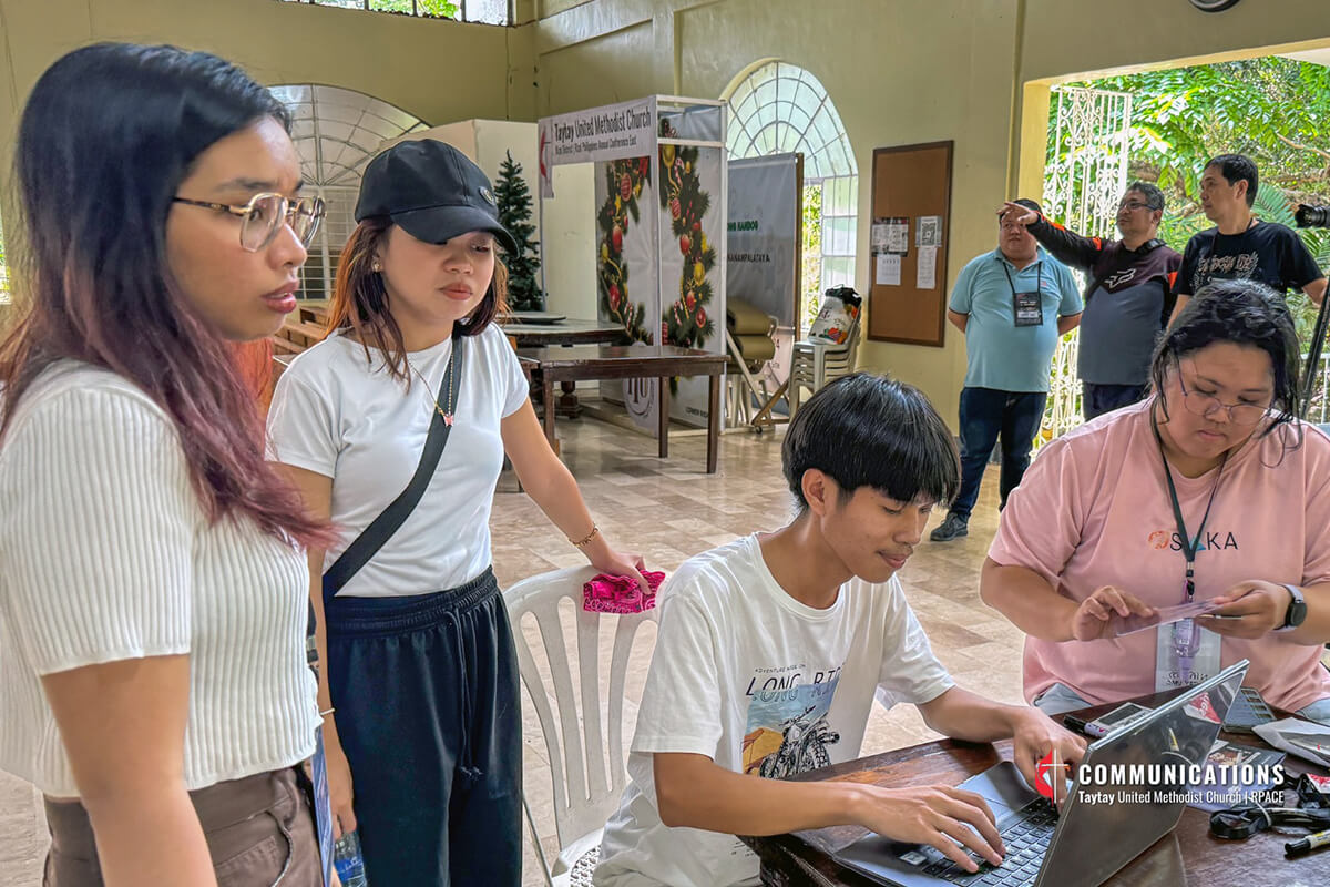People gather around a laptop during a “Tell Your Church’s Story” training event for churches in the Rizal Philippines Annual Conference East (RPACE) on March 22. The event was sponsored by the Taytay Philippines Communications team and United Methodist Communications. Image courtesy of the Taytay Philippines Communications team.