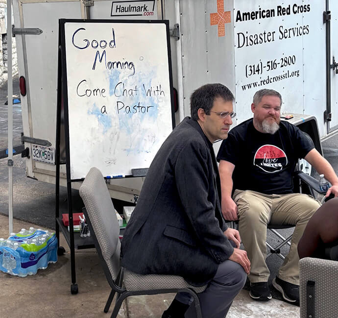 El Rev. Dan Shanks a la derecha, pastor de la Iglesia Metodista Unida de Arlington en Bridgeton, Misuri y un pastor luterano conversan en la Iglesia Metodista Unida Grace en San Luis con personas afectadas por los tornados mortales que azotaron la zona. La Iglesia Metodista Unida Grace brindó la oportunidad de recibir consejería presencial, ya que funcionaba como refugio de la Cruz Roja. Foto cortesía de la página de Facebook de la Iglesia Metodista Unida Grace. 