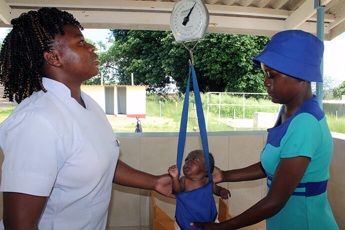 Evidence Matemachani (à gauche) pèse Takudzwa Chihwai lors de son examen de six semaines sous le regard de sa mère, Emily Chindenga, à la clinique Chindenga à Mutoko, au Zimbabwe. Ce centre est le sixième dispensaire rural de l'hôpital de la mission méthodiste unie de Nyadire à avoir été revitalisé au cours de la dernière décennie avec le soutien de The Nyadire Connection et du United Methodist Board of Global Ministries (Conseil méthodiste uni des ministères mondiaux). Photo par Kudzai Chingwe, UM News.