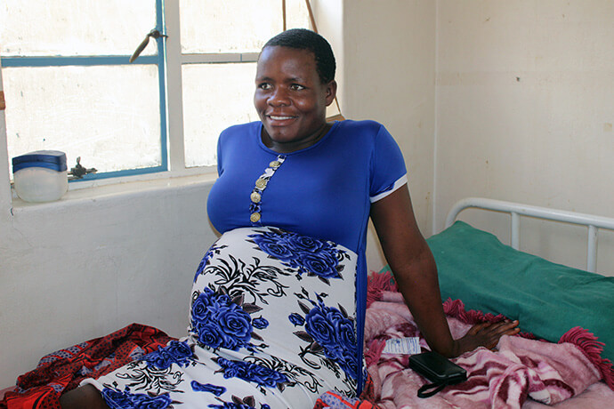 La future mère Sarah Master est assise dans l'abri d'attente de la clinique Chindenga à Mutoko, au Zimbabwe. Elle se dit satisfaite de l'hospitalité et de l'hébergement de la clinique récemment rénovée. Photo par Kudzai Chingwe, UM News.
