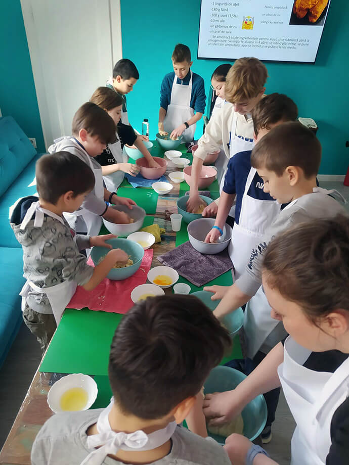 Children learn to cook as part of a United Methodist afterschool program in Sibiu, Romania. “Ukrainian and Romanian youth gather together and learn life skills as well as have time for personal development,” said the Rev. Rares Calugar, a United Methodist district superintendent. Photo courtesy of Sarah Putman.