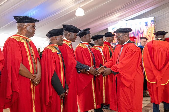O secretário permanente do Zimbabué para o Ensino Superior e Terciário e antigo vice-chanceler da Universidade de África, Fanuel Tagwira (à direita), felicita os primeiros graduados do Doutoramento inaugural do Ministério em Capelania Militar, um programa de parceria com o Seminário Teológico Wesley, ligado aos Metodistas Unidos, em Washington. Os 10 capelães masculinos, provenientes do exército, força aérea, polícia e serviços correccionais de quatro países da África Austral, formaram-se em maio. Foto cedida pelo Gabinete de Relações Públicas da Universidade de África.