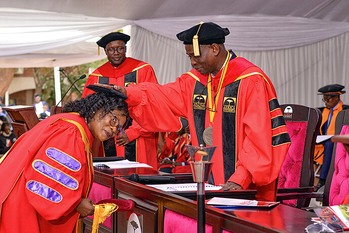 Martha Kabaira Chikowore receives an honorary doctorate from Bishop Gaspar J. Domingos, Africa University chancellor, in recognition of the role she played in the creation of Africa University’s Intellectual Property master’s program in 2008. Chikowore delivered the keynote address during the university’s 31st graduation ceremony June 7. Photo courtesy of the Africa University Public Affairs Office.