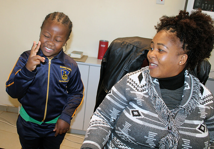 Ten-year-old Ratnali Matsvuka demonstrates how she communicates with her brother, Ishe, while visiting The United Methodist Church main office in Mutare, Zimbabwe. Her mother, Linda Matsvuka (right), is the secretary for the Zimbabwe East Conference. Photo by Kudzai Chingwe, UM News.