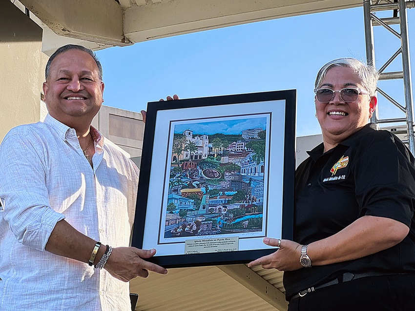 La Obispa Lizzette Gabriel Montalvo recibe de manos del alcalde de Caguas, William Miranda Torres, un cuadro con los símbolos de la ciudad como reconocimiento a la IMPR por sus 125to aniversario. Foto Rev. Gustavo Vasquez, Noticias MU.