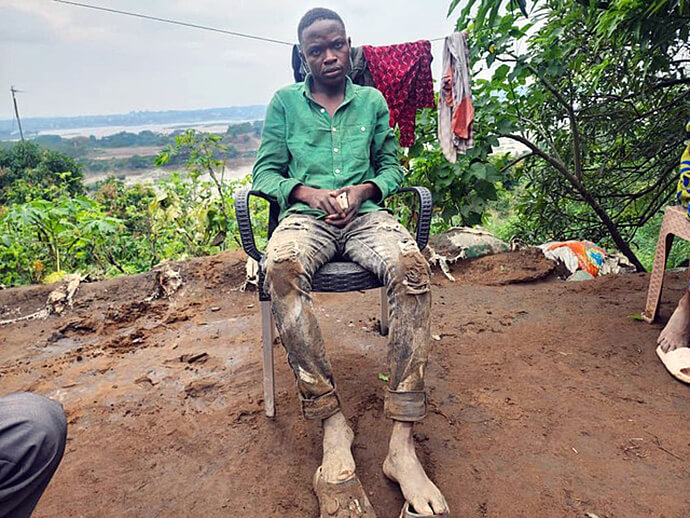 Raphael Ayakundu, jeune choriste Méthodiste Uni et survivant des inondations , est assis devant ce qui reste de sa maison à Ngaliema. Comme beaucoup de familles sinistrées, il témoigne de la détresse et de la précarité des survivants après la catastrophe qui a frappé la capitale. Photo par le révérend Fiston Okito, UM News.