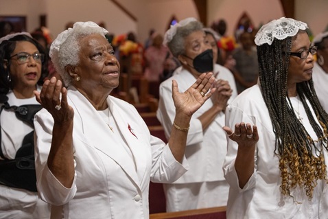Atha Brown (left, front) joins with other communion stewards in praise during worship at Hartzell Mt. Zion United Methodist Church in Slidell, La. Photo by Mike DuBose, UM News.