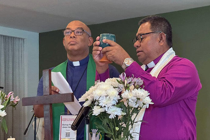 Bishops Pedro Araúz Valdéz (left) of the Evangelical Methodist Church of Panama and Antonio Trottman (right) of the Methodist Church of the Caribbean and the Americas’ Panama District preside over Holy Communion during the inaugural service of the mission consultation in Panama City. 