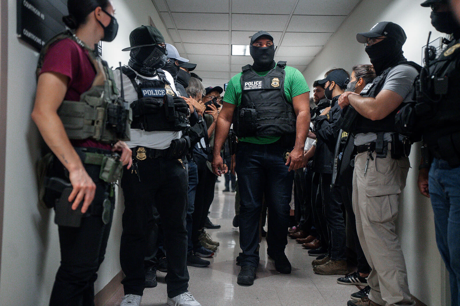 Agentes federales enmascarados esperan afuera de una sala de audiencias de inmigración el 8 de julio de 2025 en Nueva York. Foto cortesía de Olga Fedorova, AP.