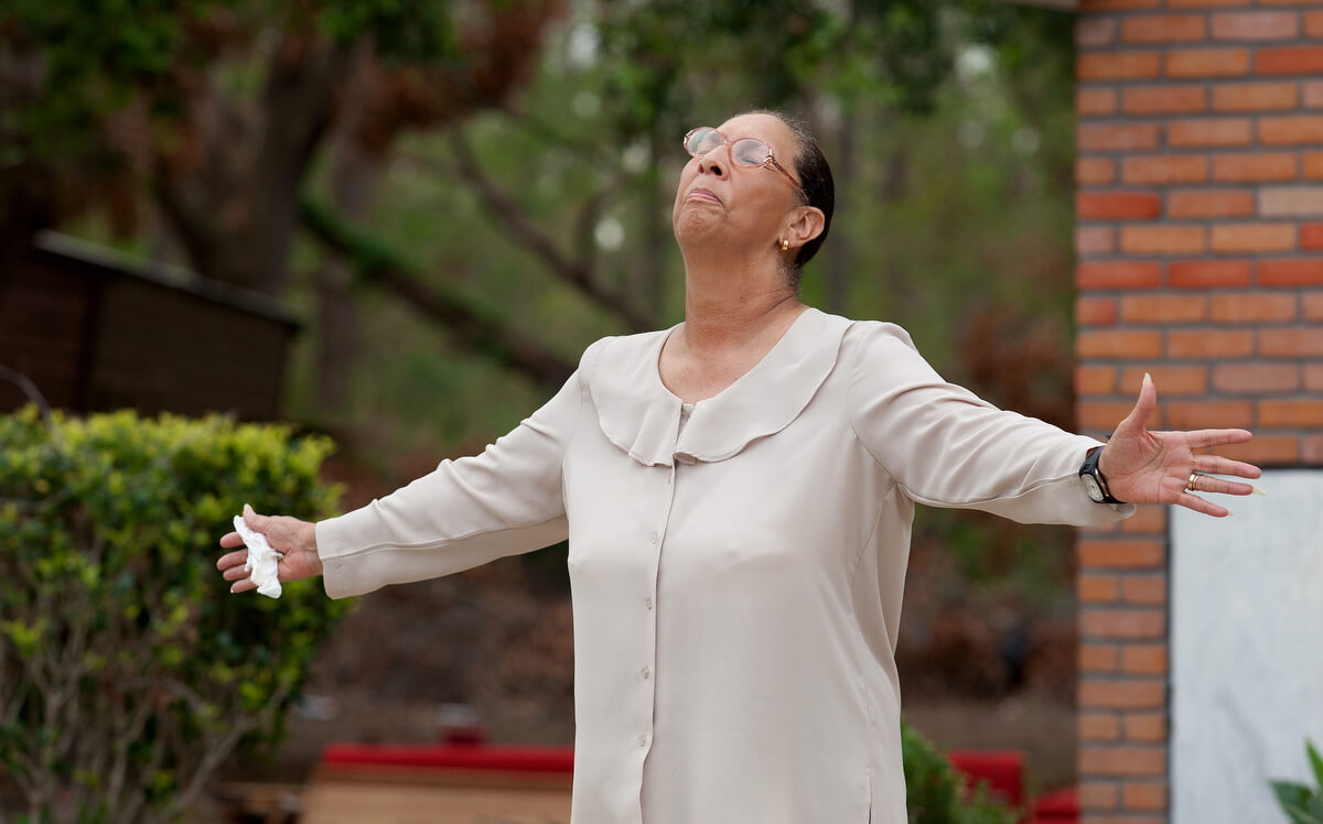 Ella Doyle lifts her head in prayer and tells fellow parishioners to “hold your head up” during an outdoor worship service at Hartzell Mt. Zion United Methodist Church in 2005. Doyle rode out the storm in a boat with her husband and two sons.