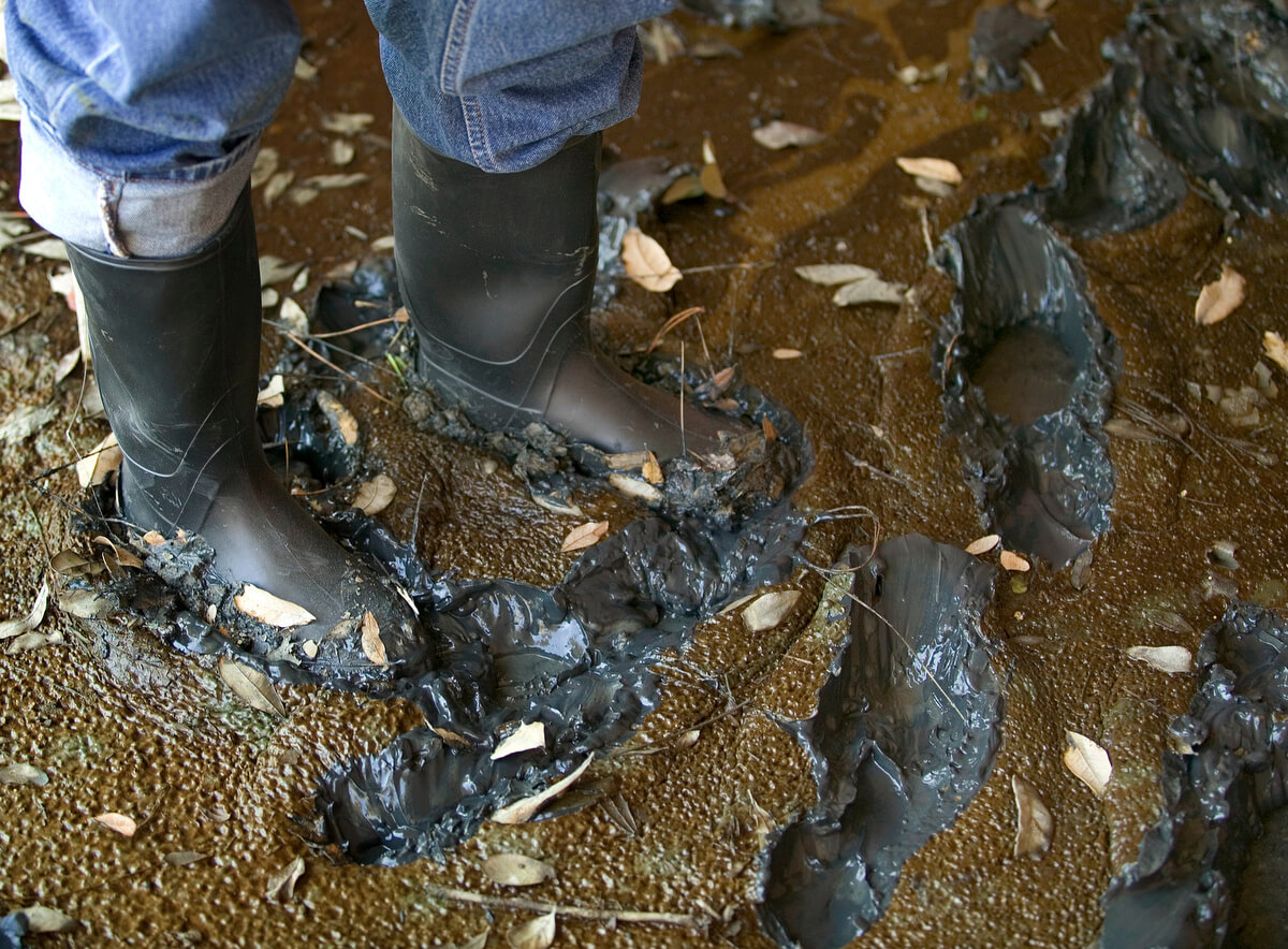 The Rev. Darryl Tate leaves deep footprints in the mud that coats the front porch of his parsonage in New Orleans following Hurricane Katrina. Photo by Mike DuBose, UM News.