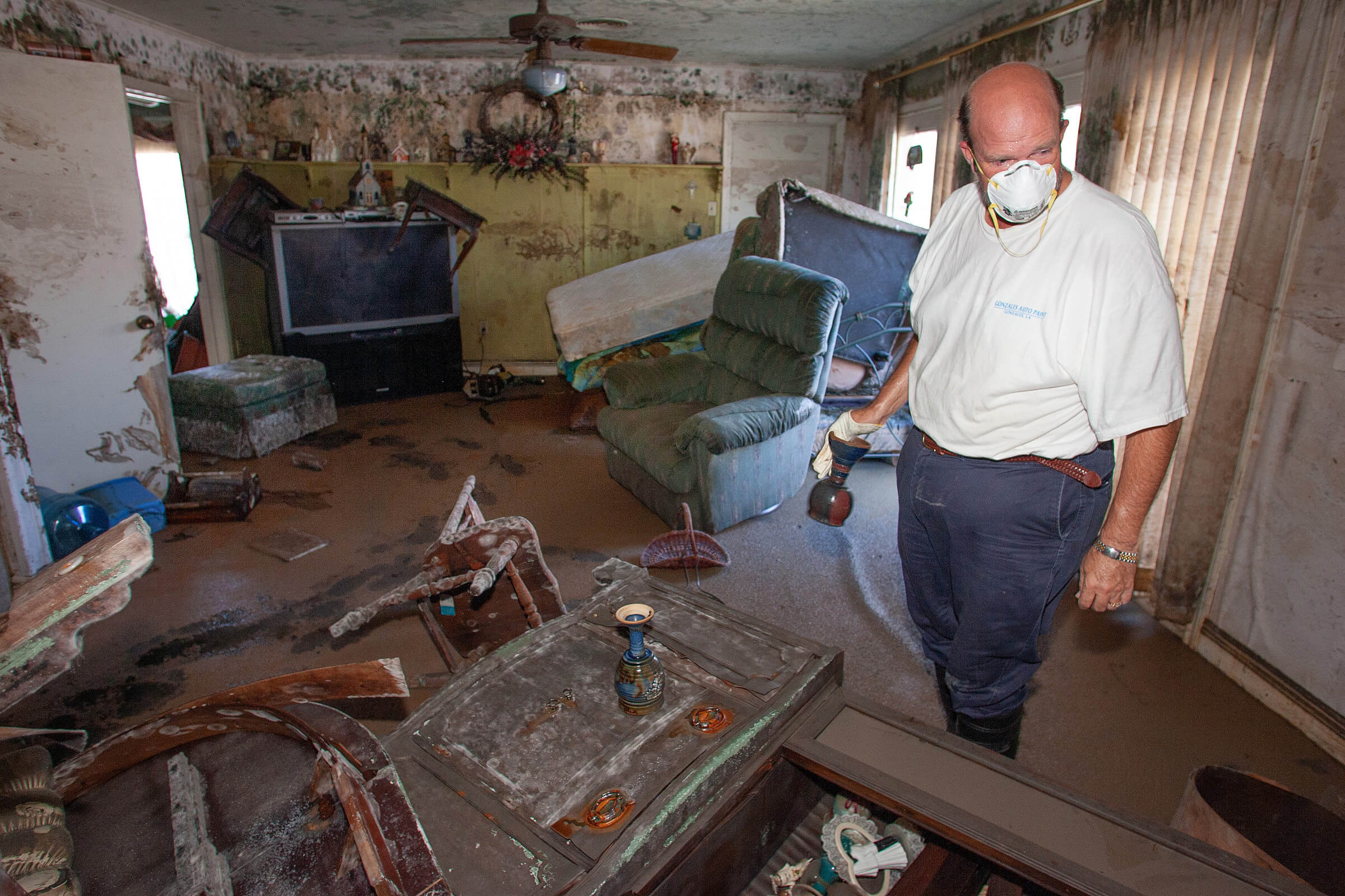 The Rev. Chris Blanchard salvages communion chalices for his friend, the Rev. Darryl Tate, from Tate’s parsonage in the Lakeview neighborhood of New Orleans following Hurricane Katrina. The chalices, a gumbo pot and the top to Tate’s wedding cake were all that could be salvaged from the home. Tate’s church, St. Luke’s United Methodist, sustained heavy damage. Photo by Mike DuBose, UM News.