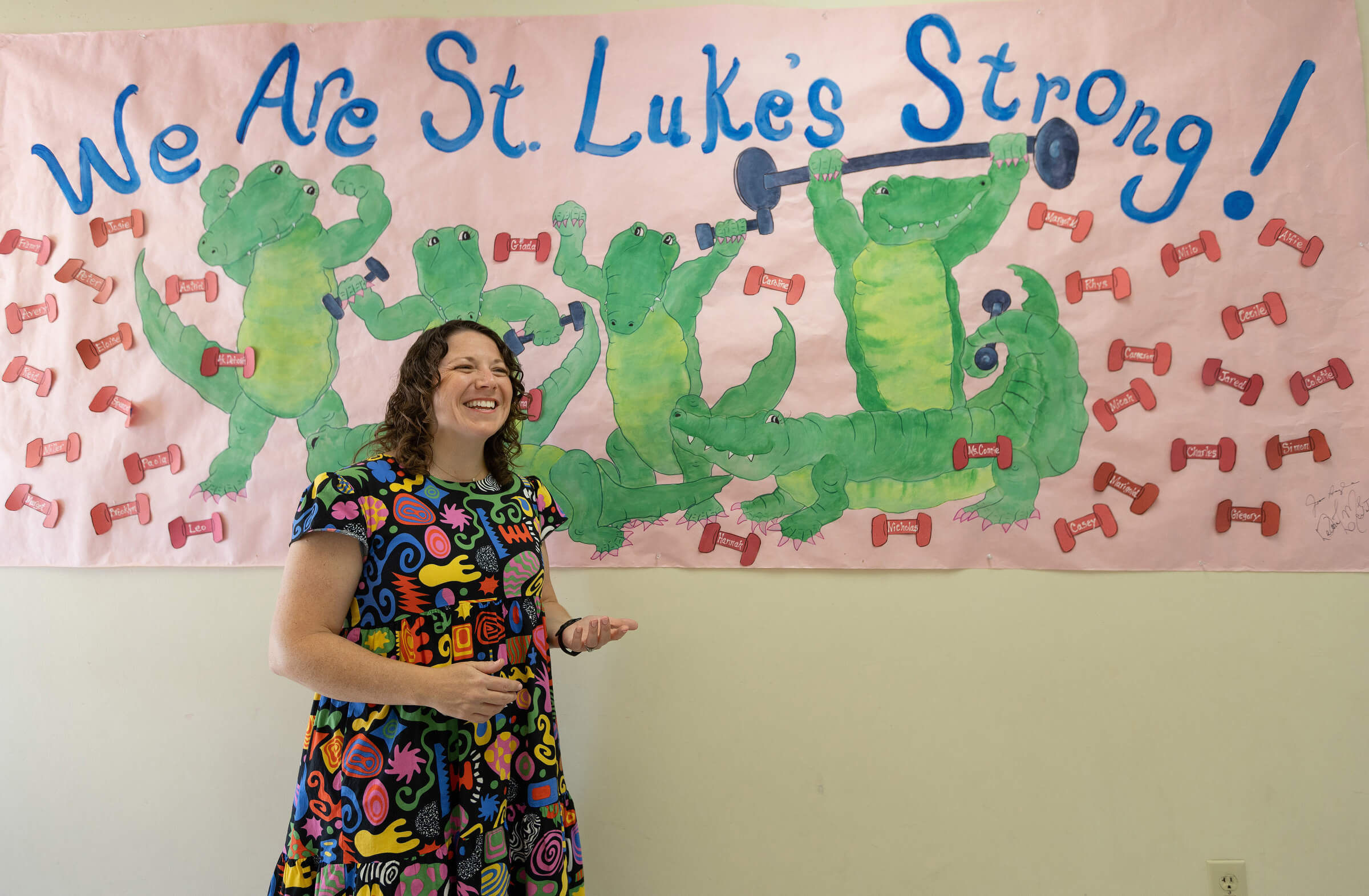 The Rev. Colleen Bookter talks about how St. Luke’s United Methodist Church in New Orleans was changed by Hurricane Katrina. She is standing in front of a poster honoring the church’s current class of nursery school students. The school was one of the first ministries of the church to reopen after Katrina. Photo by Mike DuBose, UM News.