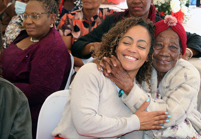Tinashe Kajese gets a hug from her grandmother, Jane Gowe, during festivities celebrating a new United Methodist sanctuary that Gowe helped establish. Kajese is one of several family members who traveled from the United States for the dedication. Photo by Kudzai Chingwe, UM News.