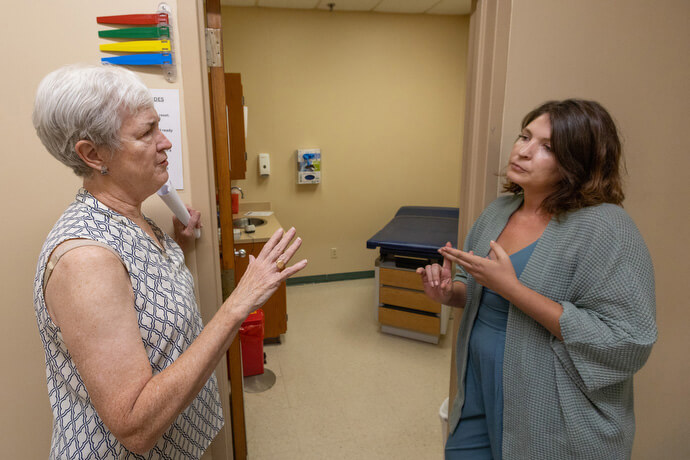 Dr. Sue Berry (left) visits with Saegan Swanson at Luke’s House, a free health clinic in New Orleans. Berry served as the clinic’s first medical director following Hurricane Katrina, and Swanson is the current executive director. Photo by Mike DuBose, UM News.